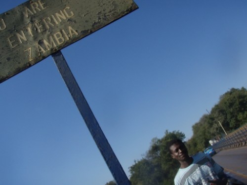 Cliff under the 'entering Zambia" sign