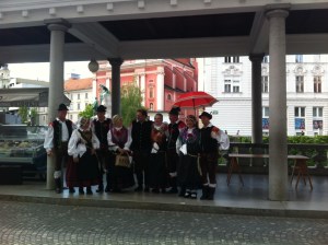 traditional Slovenian costume, in front of the pink church