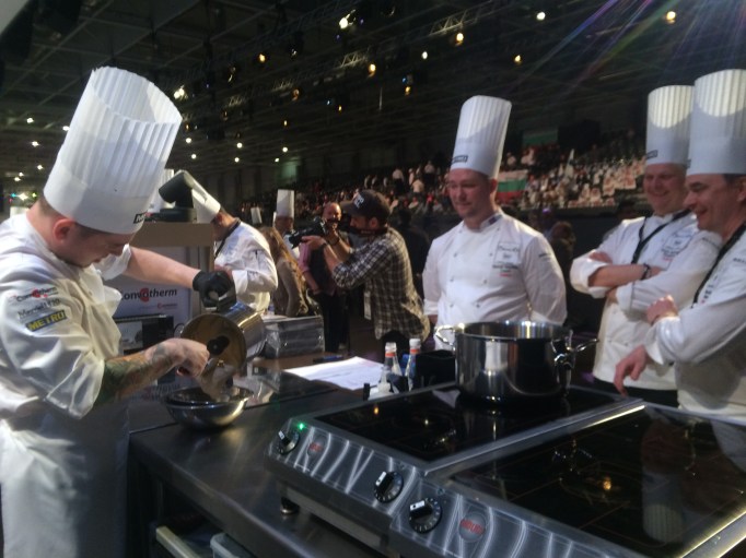 Coach Siggi Helga supporting Viktor during the competition, while the stands behing fill with screaming fans